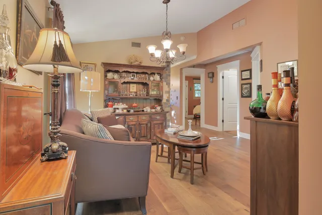 a living room with furniture a chandelier and a dining room