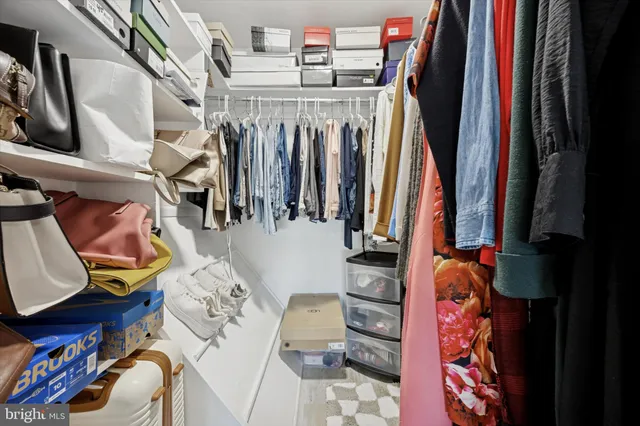 a view of walk in closet with clothes and shoes