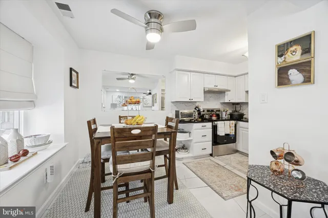 a kitchen with a dining table chairs stainless steel appliances and cabinets