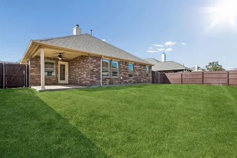 a view of a house with a yard and sitting area