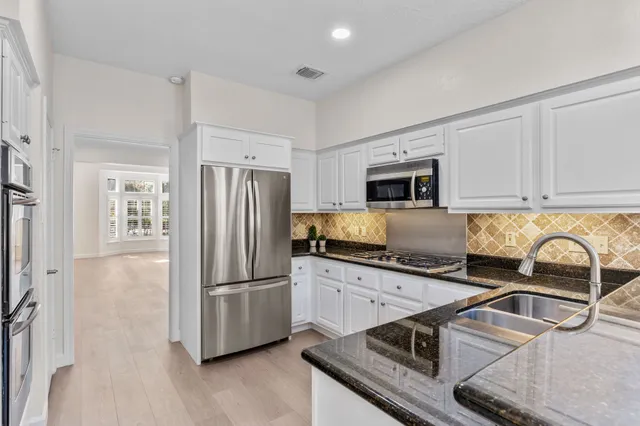 a kitchen with granite countertop a refrigerator and a sink
