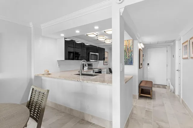 a kitchen with stainless steel appliances granite countertop a refrigerator a stove and a sink