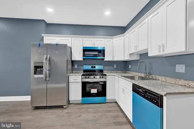 a large kitchen with a refrigerator and a stove top oven