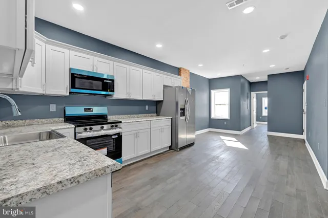 a kitchen with stainless steel appliances granite countertop a stove sink microwave and refrigerator