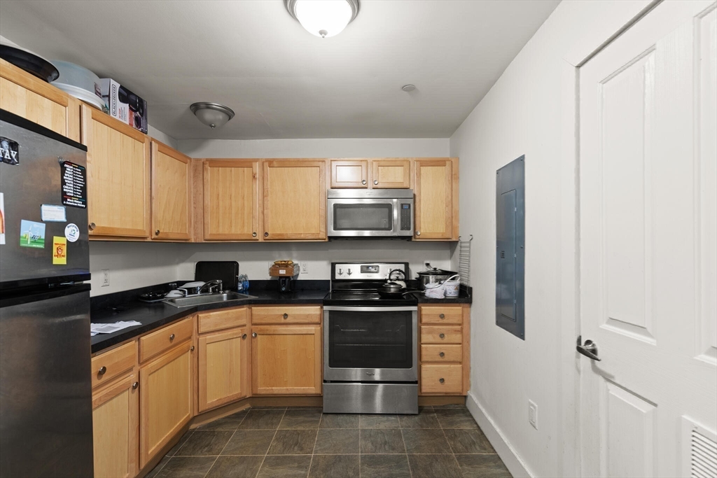 145 Lewis Street Lynn, MA 01902 - Photo 12 of 32 a kitchen with stainless steel appliances granite countertop a stove a sink and a microwave