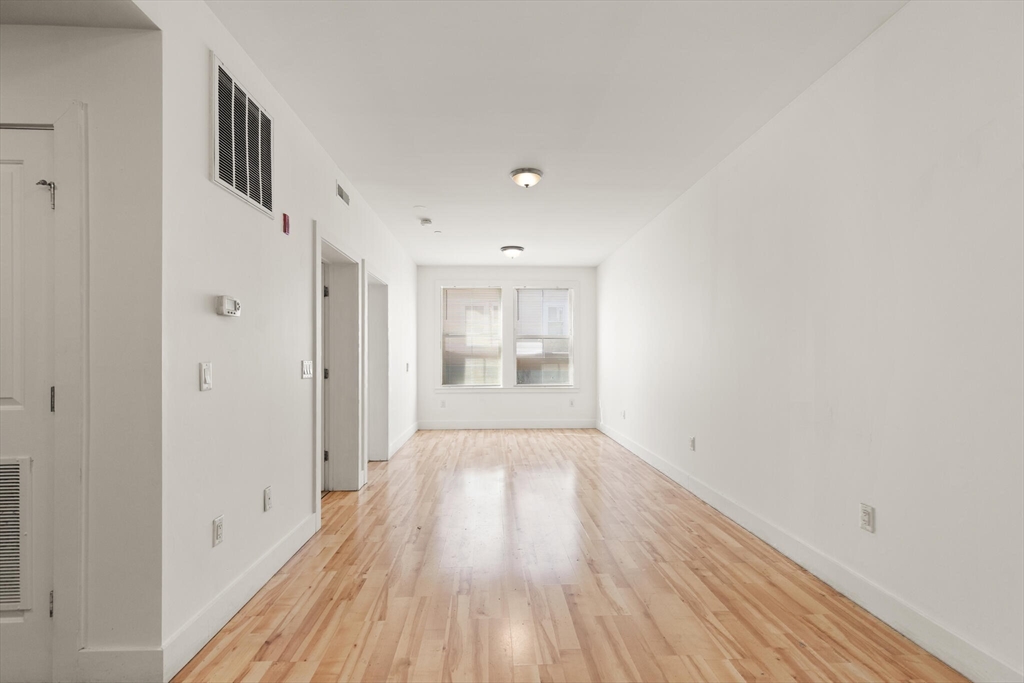 145 Lewis Street Lynn, MA 01902 - Photo 14 of 32 a view of a hallway with wooden floor and a refrigerator