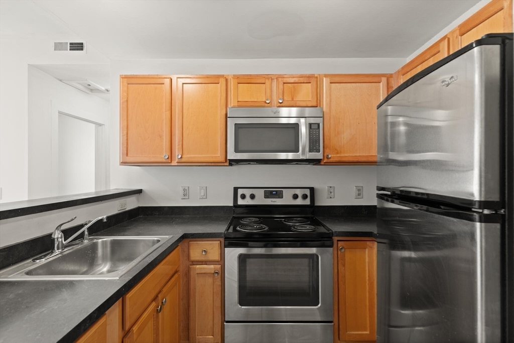 145 Lewis Street Lynn, MA 01902 - Photo 15 of 32 a kitchen with stainless steel appliances granite countertop a sink stove and microwave