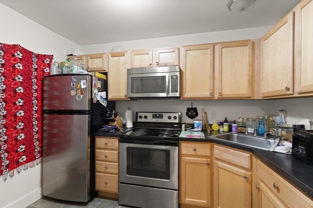 145 Lewis Street Lynn, MA 01902 - Photo 21 of 32 a kitchen with stainless steel appliances granite countertop a refrigerator sink and cabinets