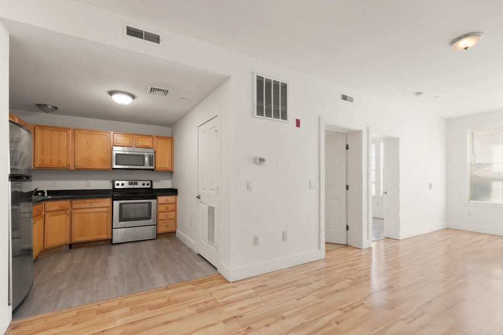 145 Lewis Street Lynn, MA 01902 - Photo 22 of 32 a large kitchen with stainless steel appliances granite countertop a stove and a sink