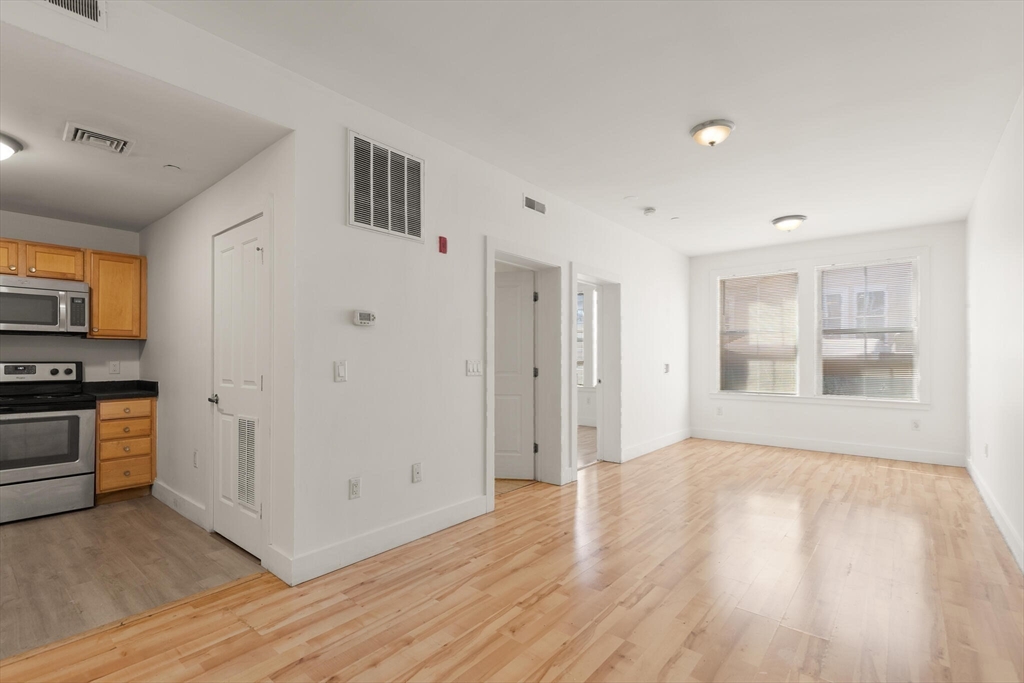 145 Lewis Street Lynn, MA 01902 - Photo 9 of 32 a view of a kitchen with wooden floor and a refrigerator