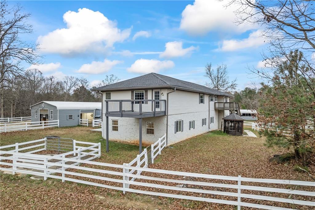 2150 Smyrna Ridge Court Southwest Conyers, GA 30094 - Photo 114 of 125 a view of a white house with a large tree and wooden fence