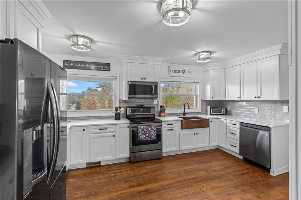 2150 Smyrna Ridge Court Southwest Conyers, GA 30094 - Photo 28 of 125 a kitchen with stainless steel appliances granite countertop a stove top oven a refrigerator and a sink