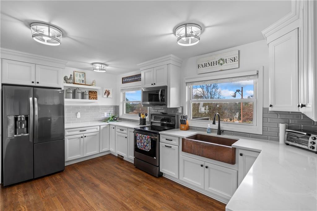 2150 Smyrna Ridge Court Southwest Conyers, GA 30094 - Photo 35 of 125 a kitchen with stainless steel appliances granite countertop a refrigerator a stove a sink and a microwave
