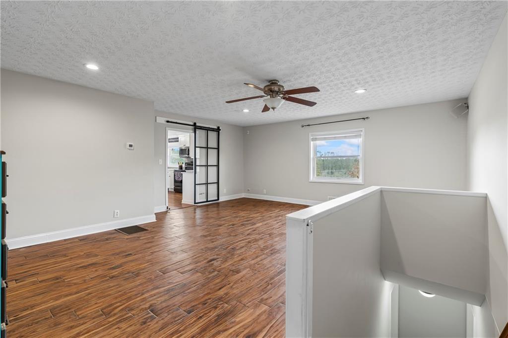 2150 Smyrna Ridge Court Southwest Conyers, GA 30094 - Photo 40 of 125 a view of an empty room with a window and wooden floor