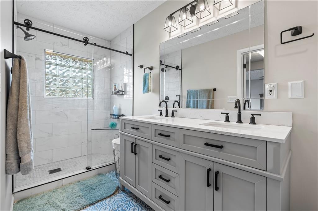 2150 Smyrna Ridge Court Southwest Conyers, GA 30094 - Photo 51 of 125 a bathroom with a double vanity sink mirror and shower