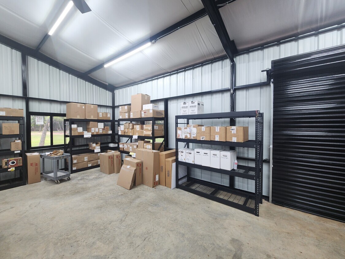 102 County Road 180 Leander, TX 78641 - Photo 24 of 25 Secure, spacious commercial storage unit with sturdy shelving and convenient roll-up access.