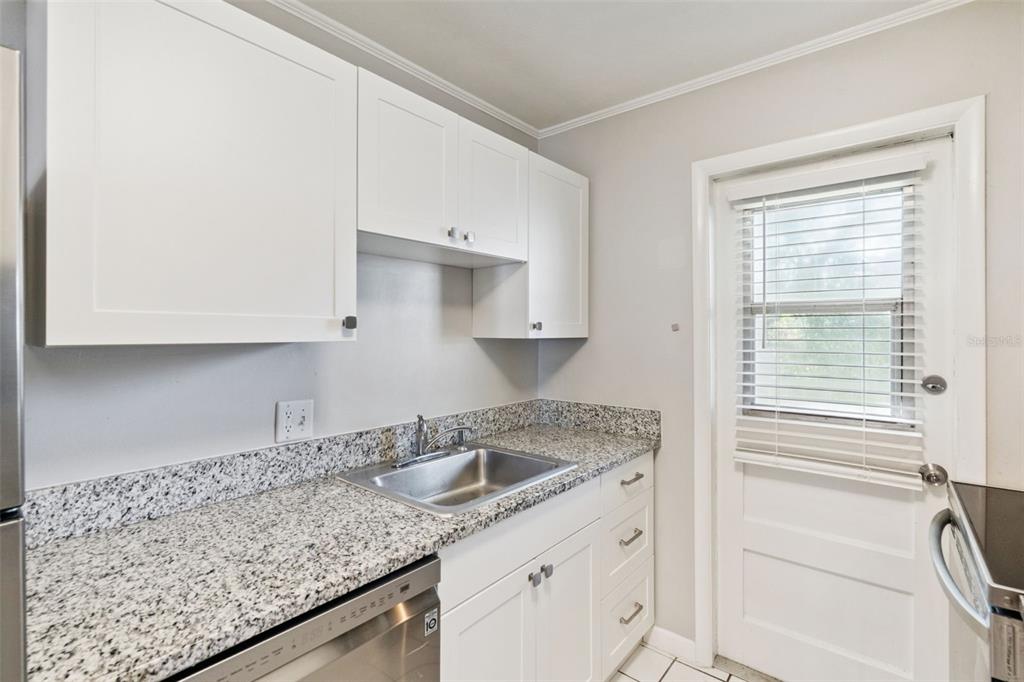 320 Lakeview Street, Unit 213 Orlando, FL 32804 - Photo 10 of 24 a kitchen with granite countertop white cabinets and a sink