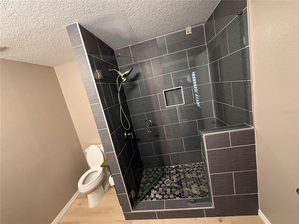 3753 Herlong Street New Port Richey, FL 34655 - Photo 12 of 18 a bathroom with a toilet and a shower