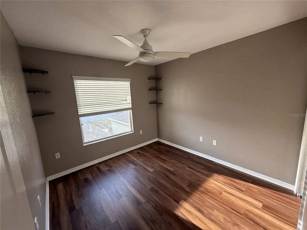 3753 Herlong Street New Port Richey, FL 34655 - Photo 17 of 18 an empty room with wooden floor fan and windows