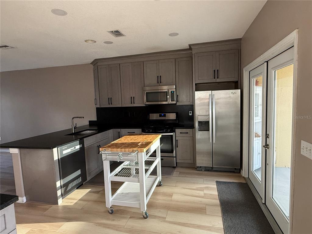 3753 Herlong Street New Port Richey, FL 34655 - Photo 5 of 18 a kitchen with stainless steel appliances granite countertop a refrigerator a stove a sink and a stove
