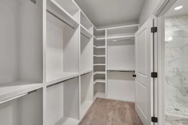 a view of walk in closet with empty racks