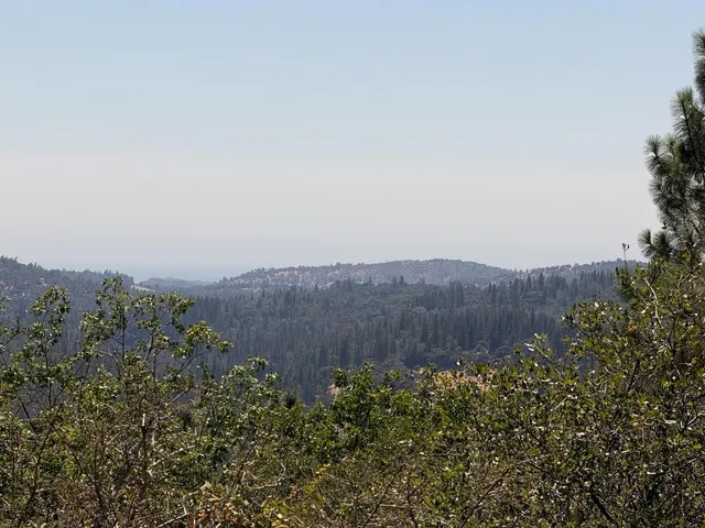 an aerial view of mountain and grassy field