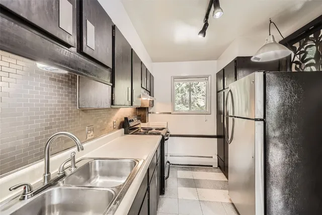 a kitchen with stainless steel appliances granite countertop a refrigerator and a sink