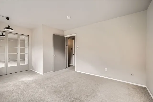 an empty room with windows and closet