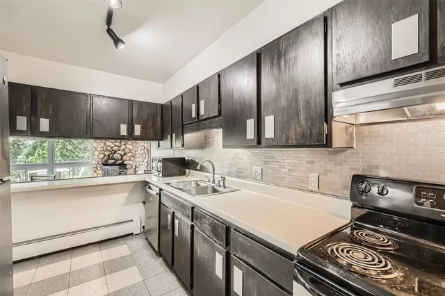 a kitchen with stainless steel appliances a sink stove and cabinets