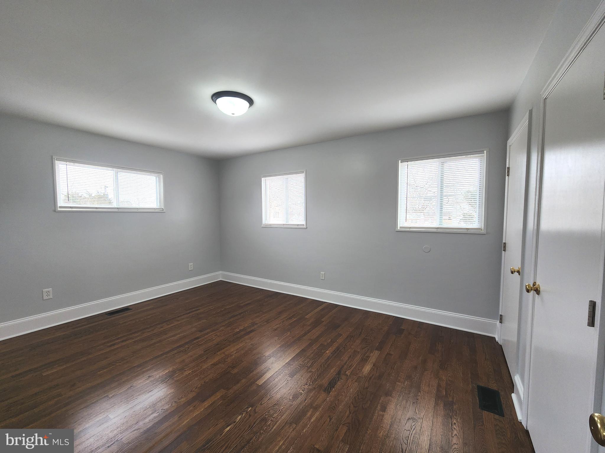 914 Vanderwood Road Catonsville, MD 21228 - Photo 10 of 23 an empty room with wooden floor and windows