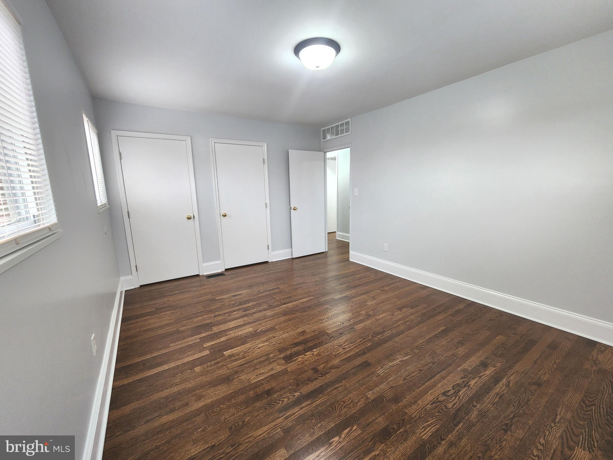 914 Vanderwood Road Catonsville, MD 21228 - Photo 11 of 23 an empty room with wooden floor and windows