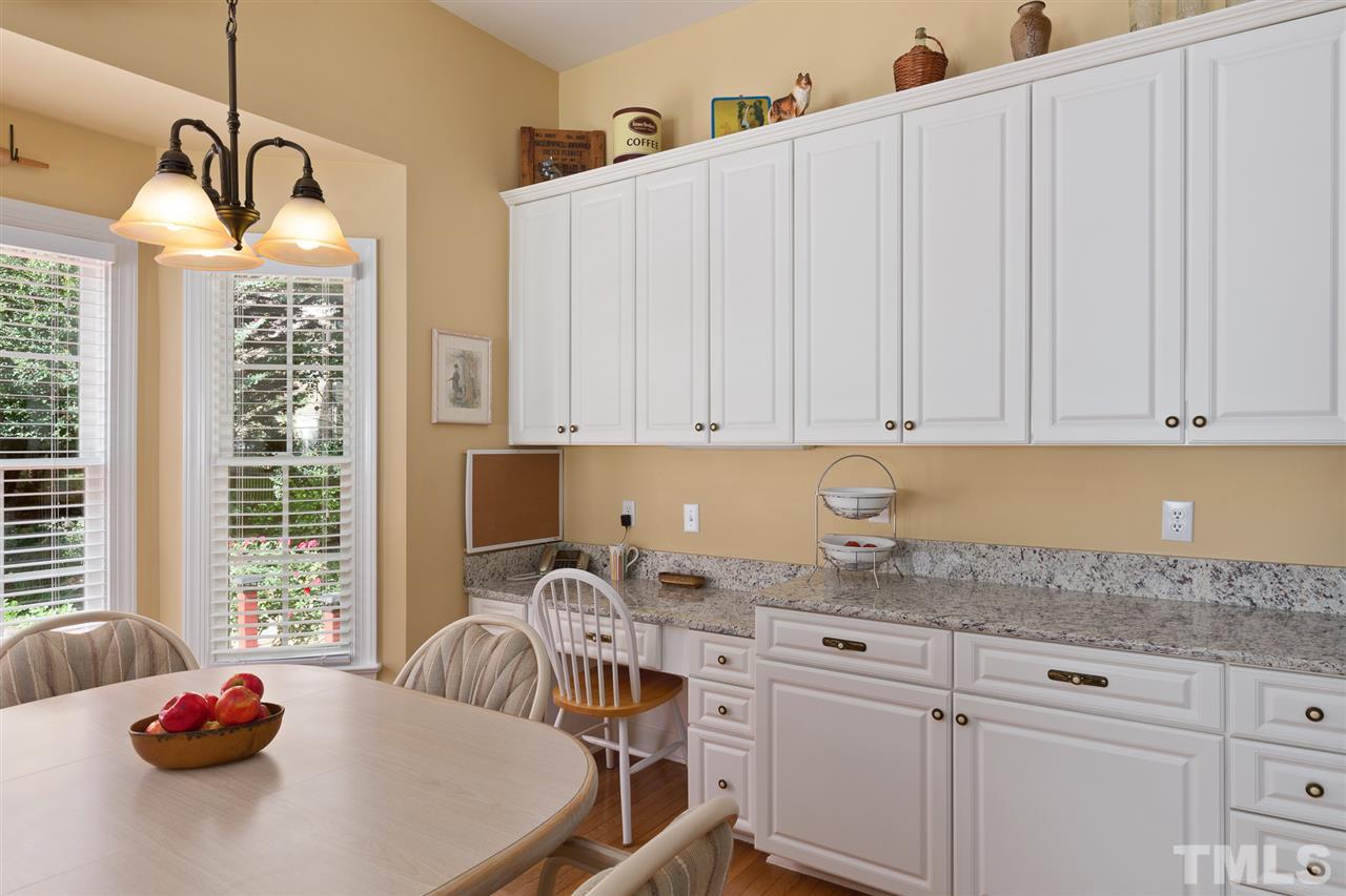 4008 Batiste Road Raleigh, NC 27613 - Photo 11 of 24 a kitchen with stainless steel appliances granite countertop a sink dishwasher and white cabinets with wooden floor