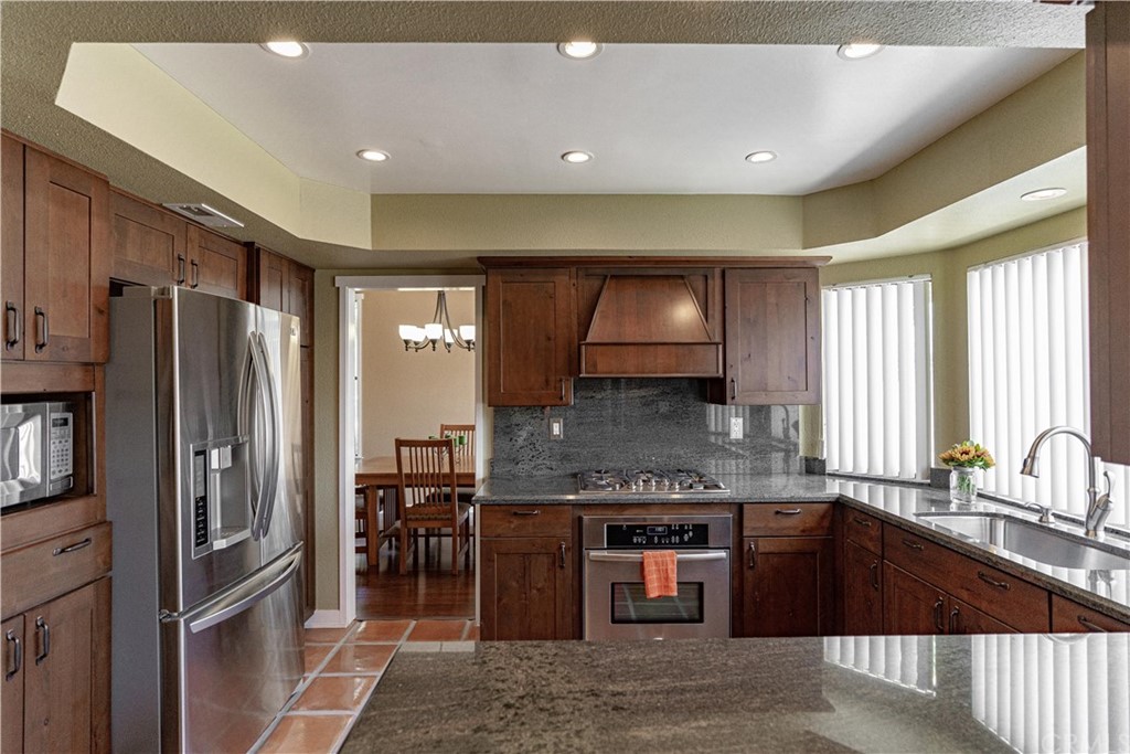 1435 Athena West Covina, CA 91790 - Photo 16 of 45 a kitchen with stainless steel appliances granite countertop a refrigerator a sink a stove and island