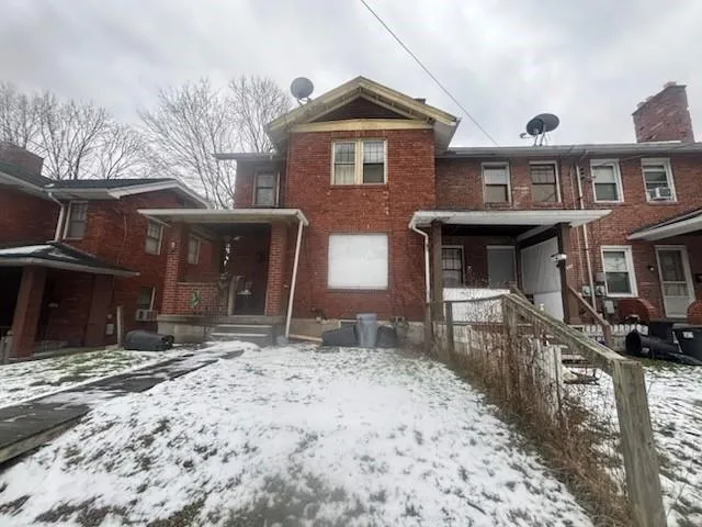 a front view of a house with a yard covered with snow in front of house