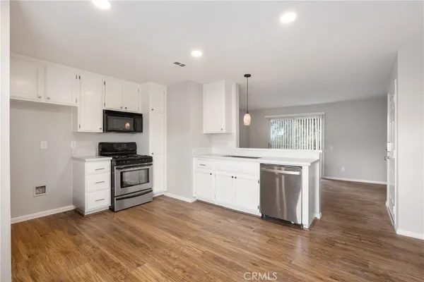 a kitchen with granite countertop a stove a sink and a refrigerator