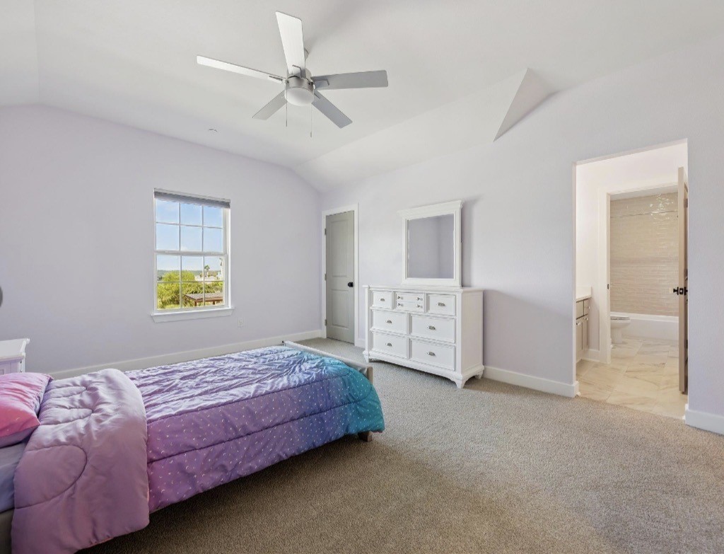 6817 Davenport Divide Road Austin, TX 78738 - Photo 19 of 28 a bedroom with a bed and a chandelier