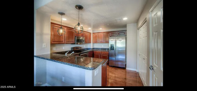 a kitchen with stainless steel appliances granite countertop a sink a stove and a refrigerator
