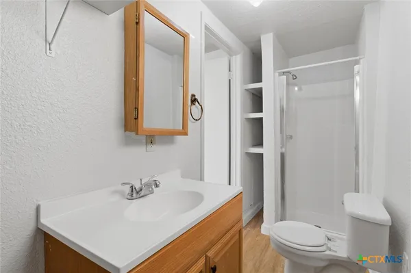 a bathroom with a sink a toilet and shower