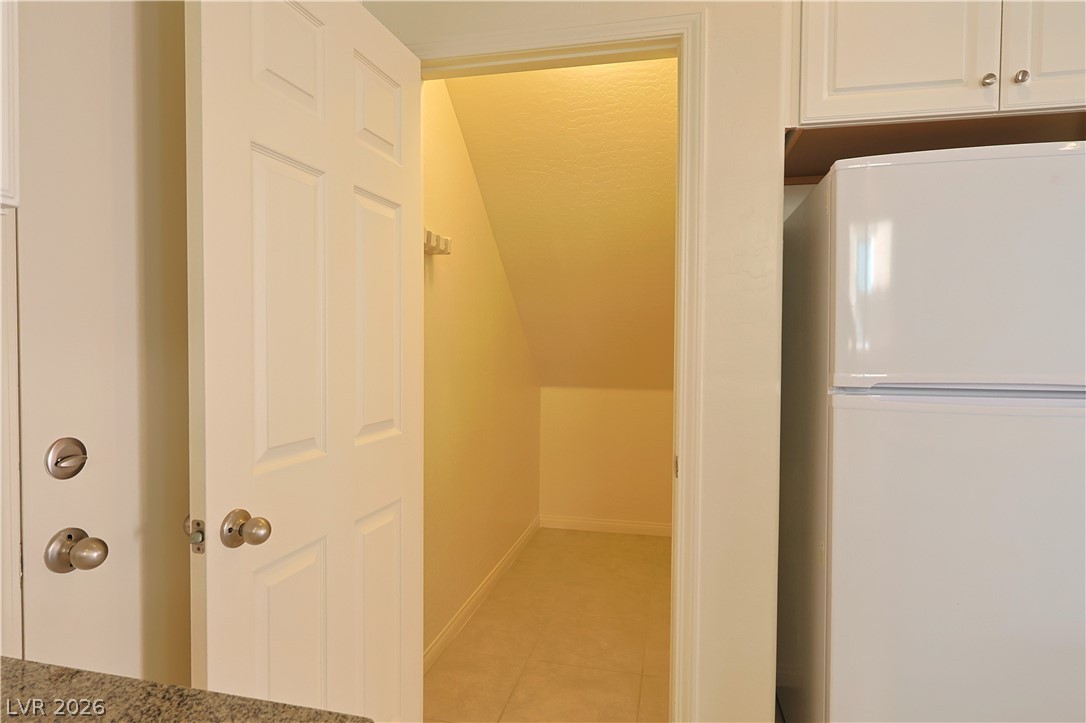 8663 Reynolds Spring Street Las Vegas, NV 89178 - Photo 12 of 32 An open door reveals a versatile under-stairs storage space adjacent to the kitchen area.