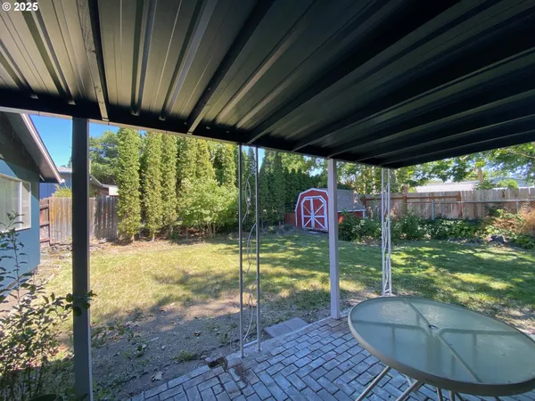 a backyard of a house with table and chairs