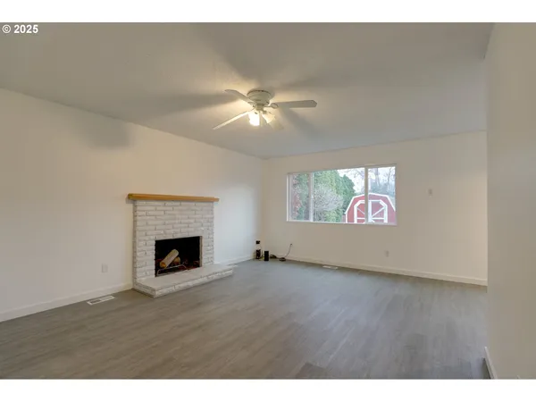 a view of an empty room fire place and a window