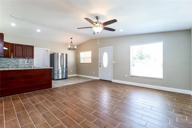an empty room with wooden floor and a window