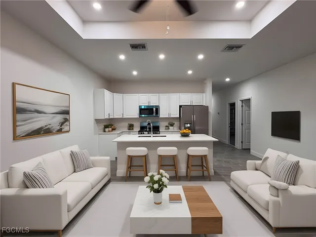 a living room with furniture kitchen view and a chandelier