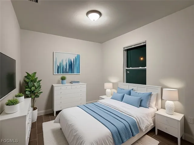 a bedroom with a bed tv and a window