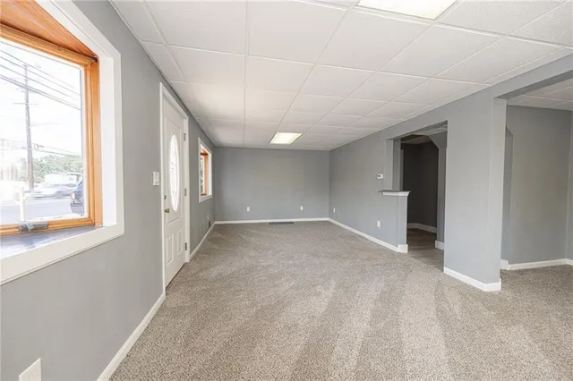 a view of a big room with windows and chandelier fan
