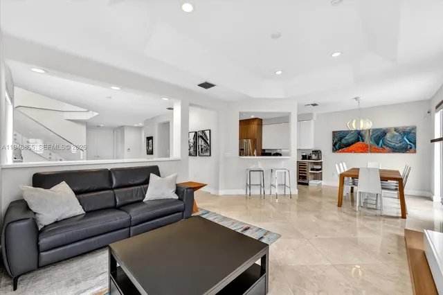 a living room with furniture and a dining table with kitchen view