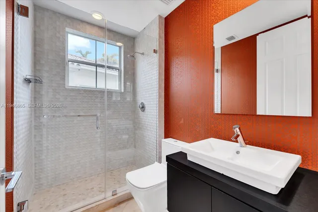 a bathroom with a sink a toilet and shower