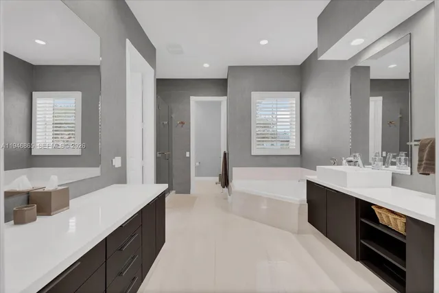 a large bathroom with a double vanity sink a large mirror and a bathtub
