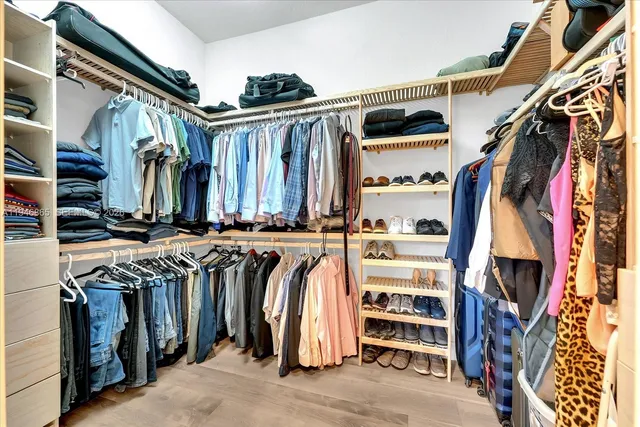 a view of walk in closet with clothes and shoes