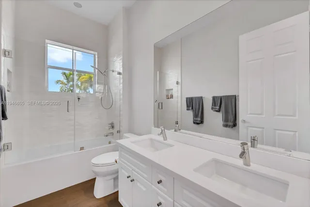 a bathroom with a double vanity sink toilet and shower